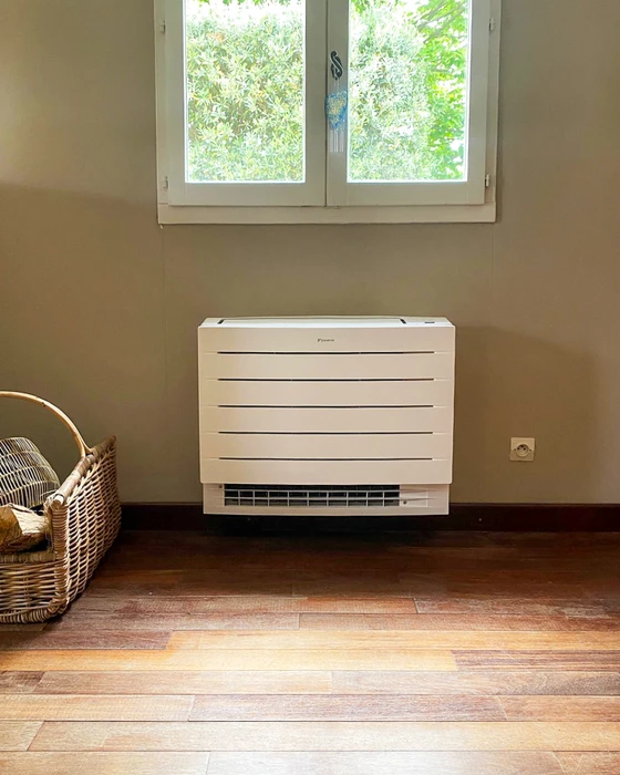 Intérieur résidentiel, plancher bois, mur beige, fenêtre double battant avec végétation