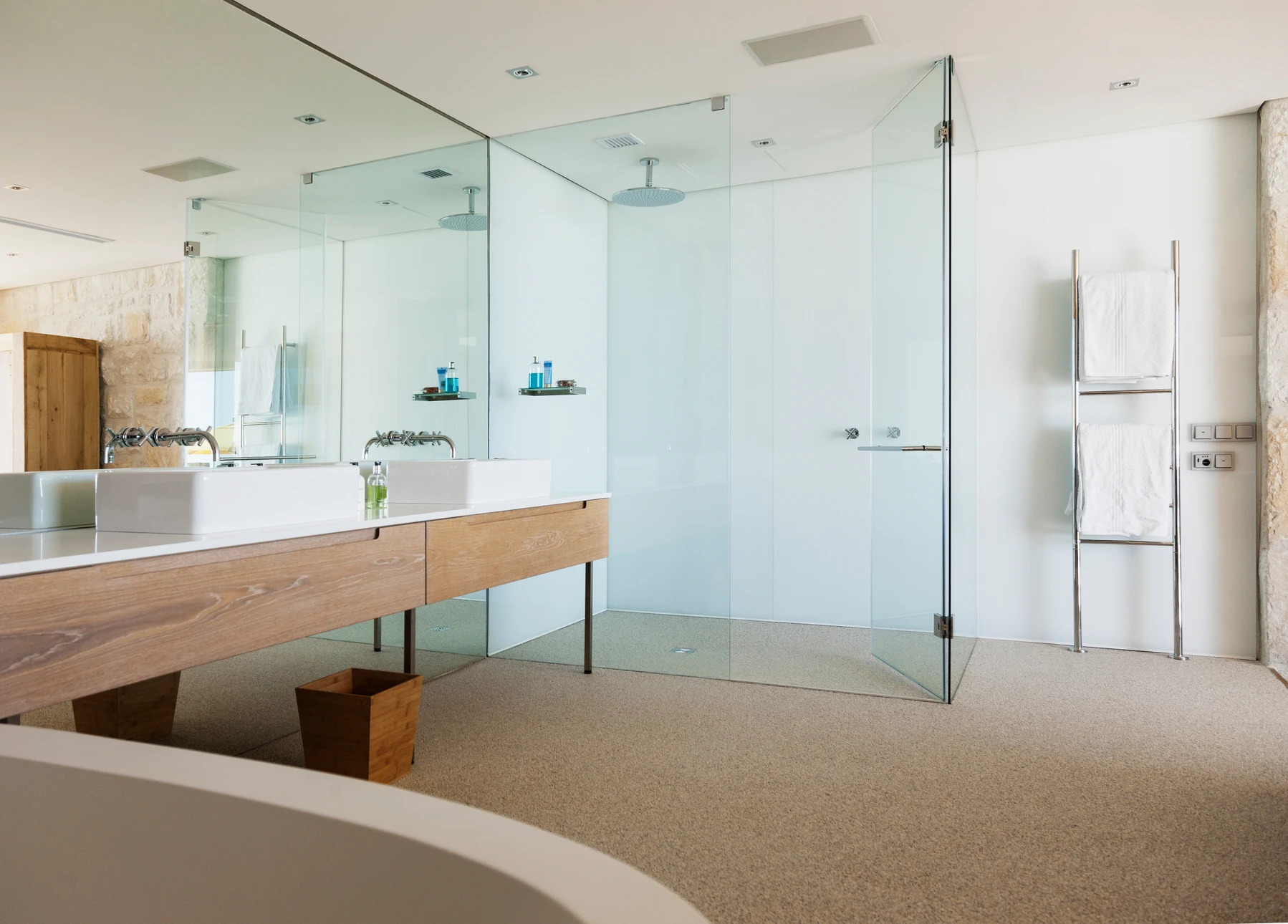 Salle de bain moderne avec douche à l'italienne vitrée, vasque double sur meuble suspendu en bois clair, robinetterie murale chromée