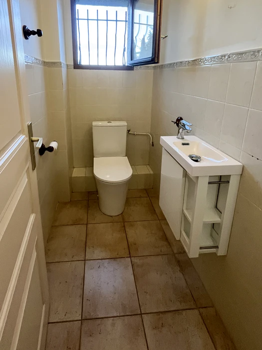 WC séparé avec toilette à réservoir attenant blanc, vasque suspendue compacte sur meuble ouvert blanc, robinetterie chromée mitigeur