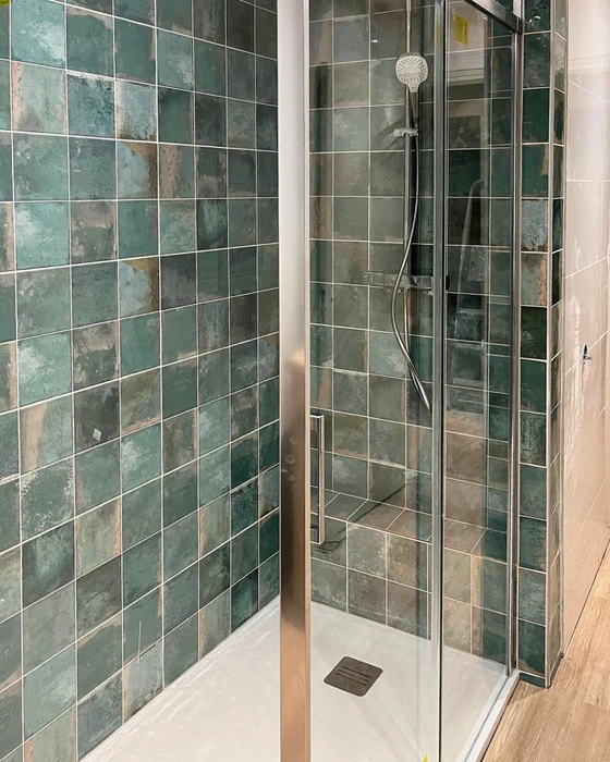 Cabine de douche avec parois en carreaux de faïence effet zellige coloris vert émeraude vieilli, pose droite en grille