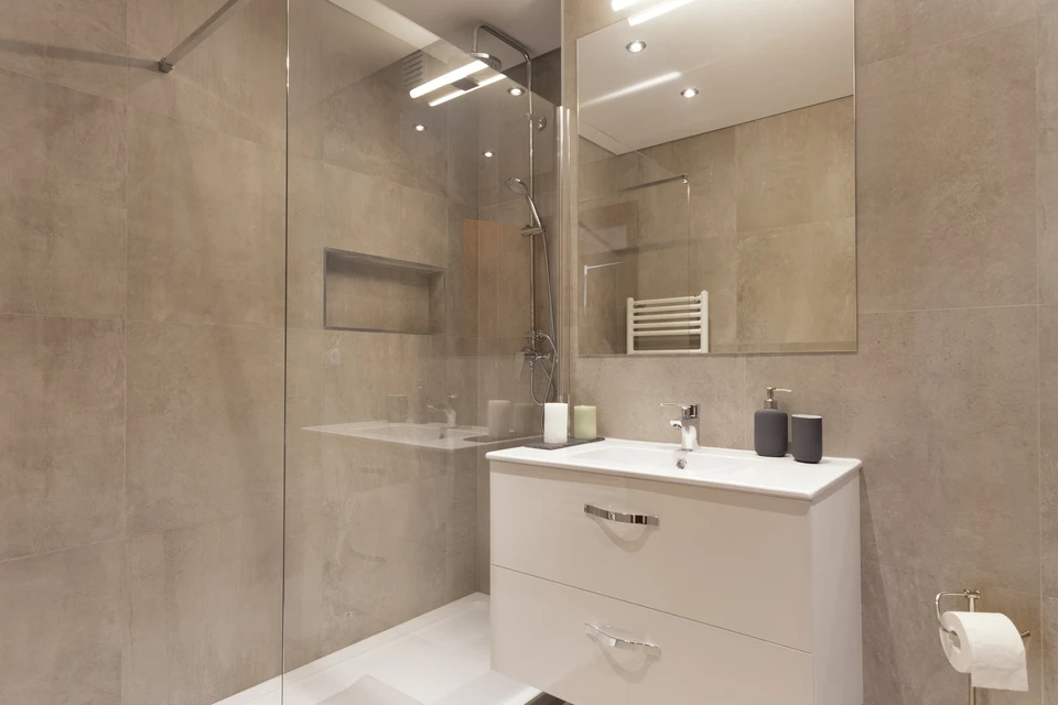 Photo d'un artisan plombier-chauffagiste en tenue professionnelle, travaillant sur l'installation d'une pompe &agrave; chaleur ou d'un syst&egrave;me de climatisation complexe dans un chantier de b&acirc;ti ancien ou avec contraintes architecturales visibles. L'artisan est concentr&eacute; sur son travail technique, manipulant des tuyauteries ou des composants du syst&egrave;me. La sc&egrave;ne doit transmettre la ma&icirc;trise technique, l'expertise et la capacit&eacute; &agrave; intervenir sur des installations exigeantes.