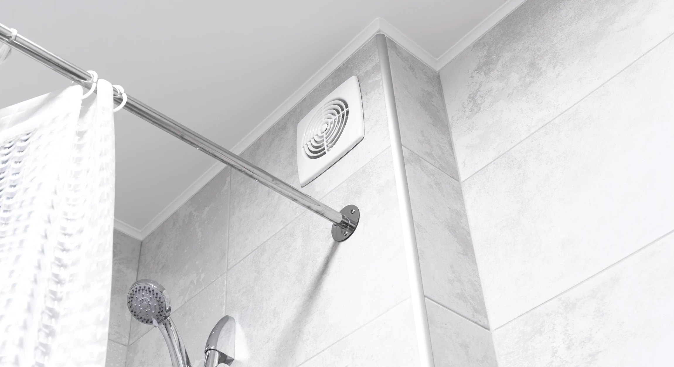 Un technicien en casque de sécurité blanc installe ou répare un système de ventilation au plafond d'un intérieur moderne