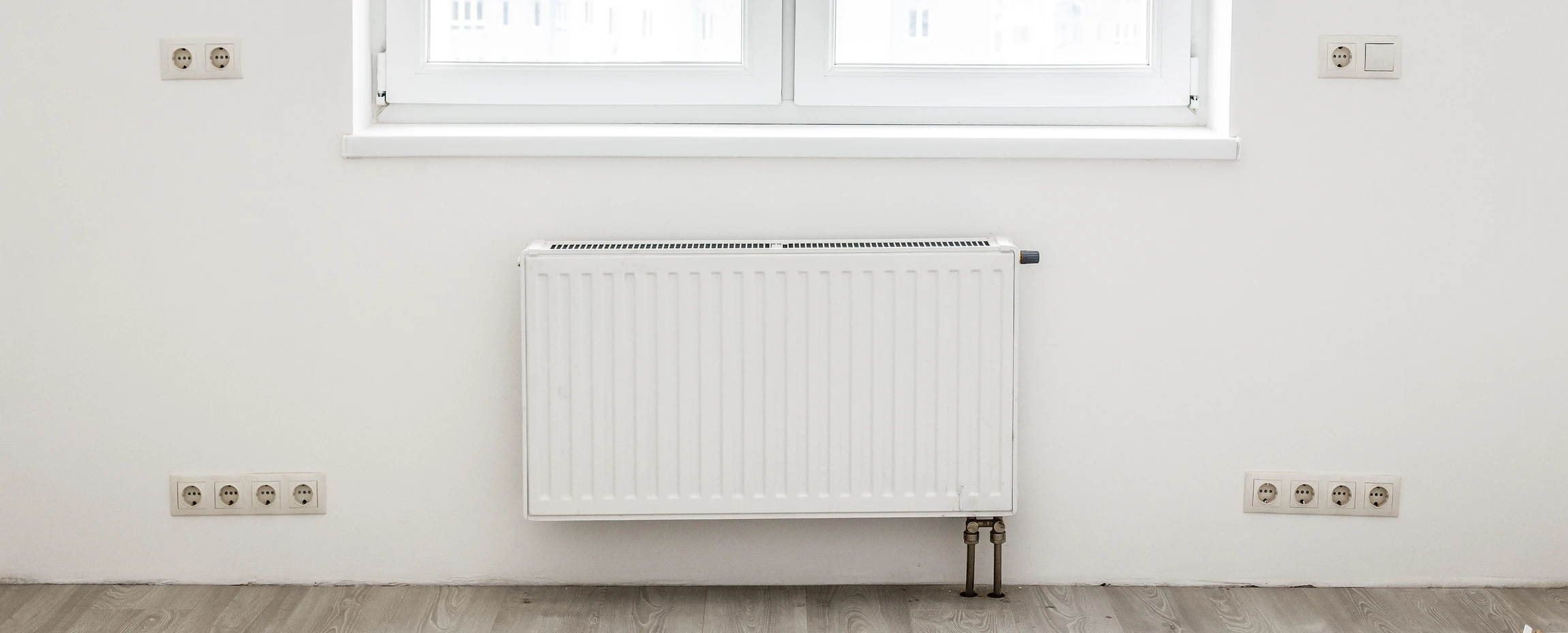 Un plombier utilise une clé à molette pour serrer un raccord de robinetterie sous un évier de cuisine