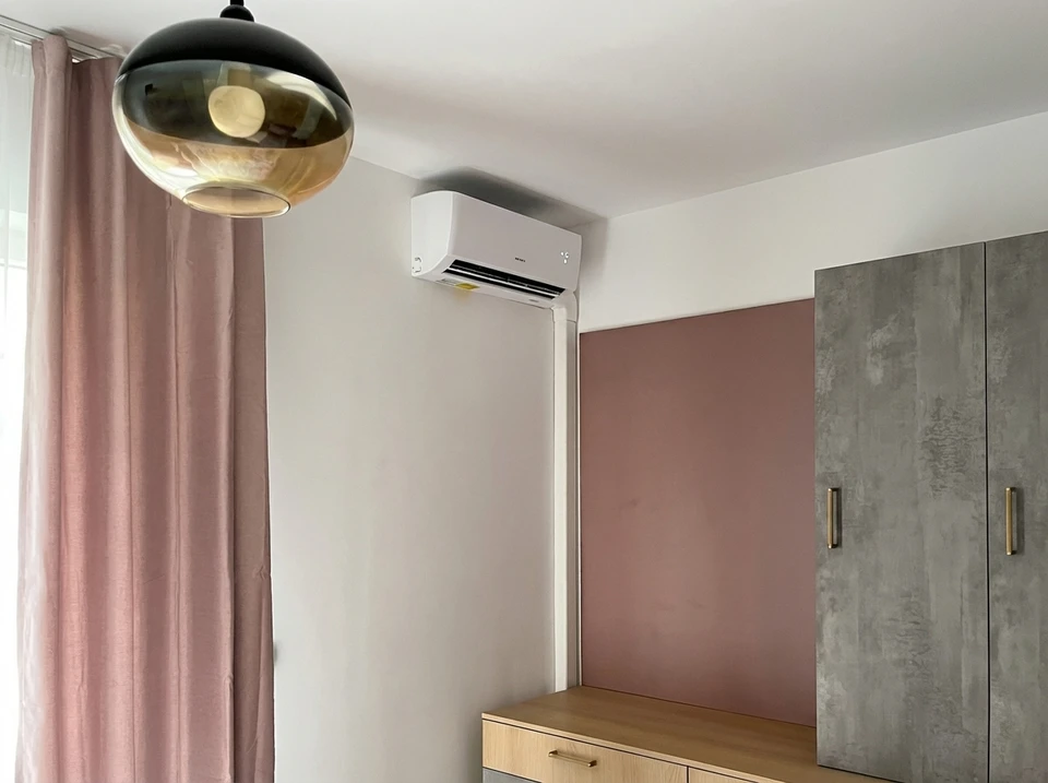 Technicien en climatisation effectuant la maintenance d'une unité murale intérieure