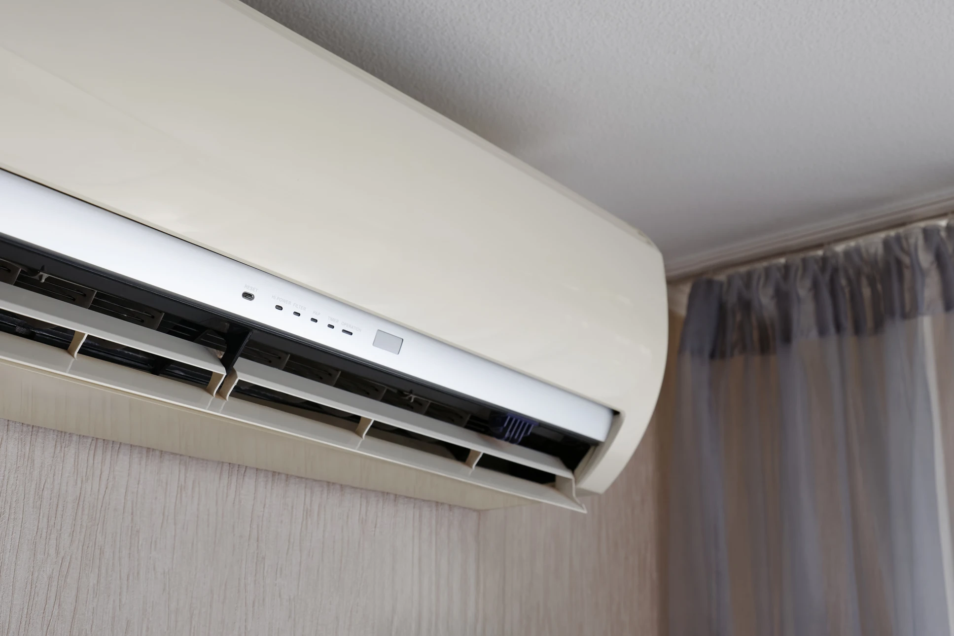 Intérieur résidentiel, personne effectuant la maintenance d'une unité de climatisation murale